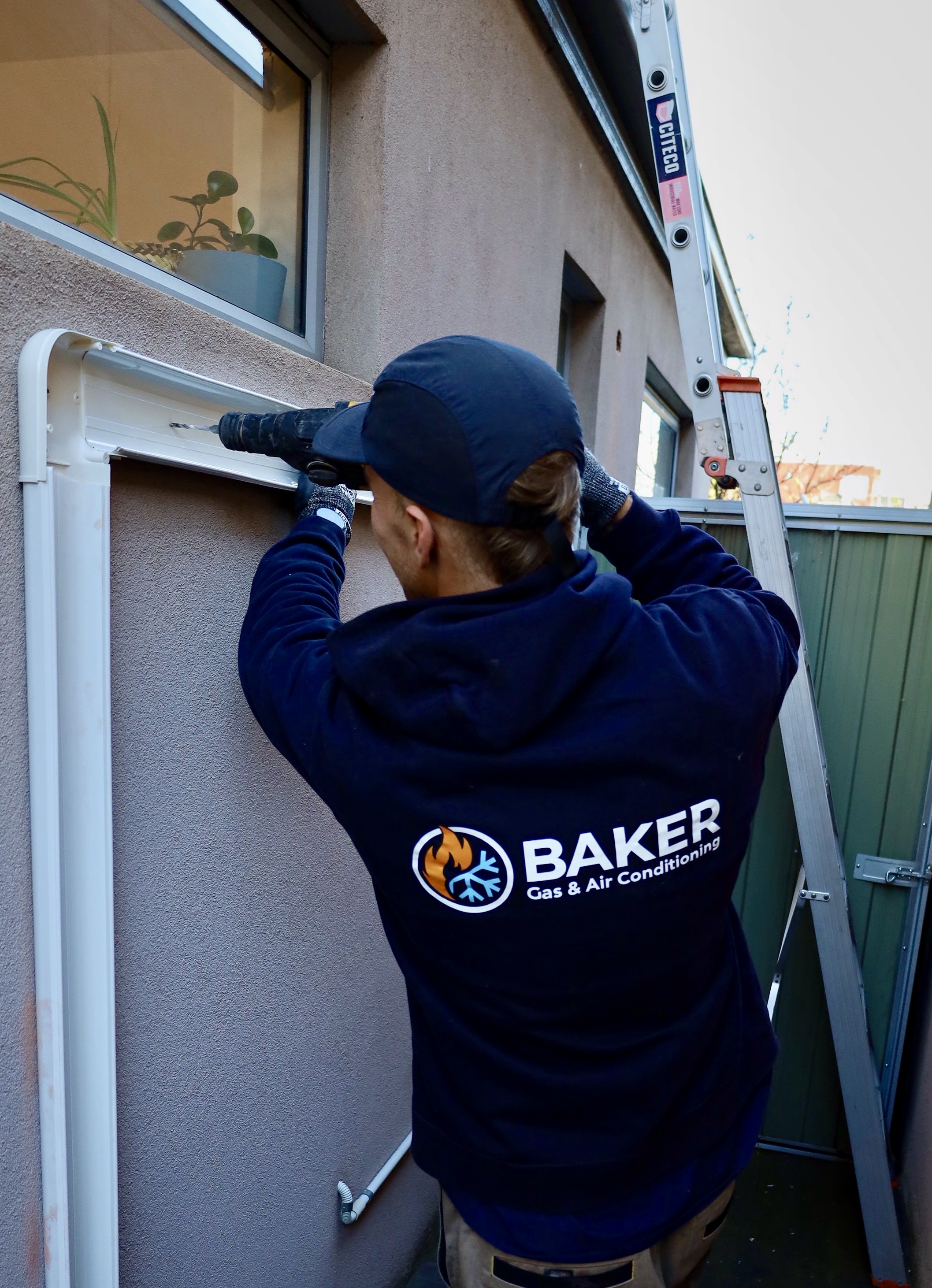 Baker Gas & Air Conditioning technician installing a split system pipe run on a residential property